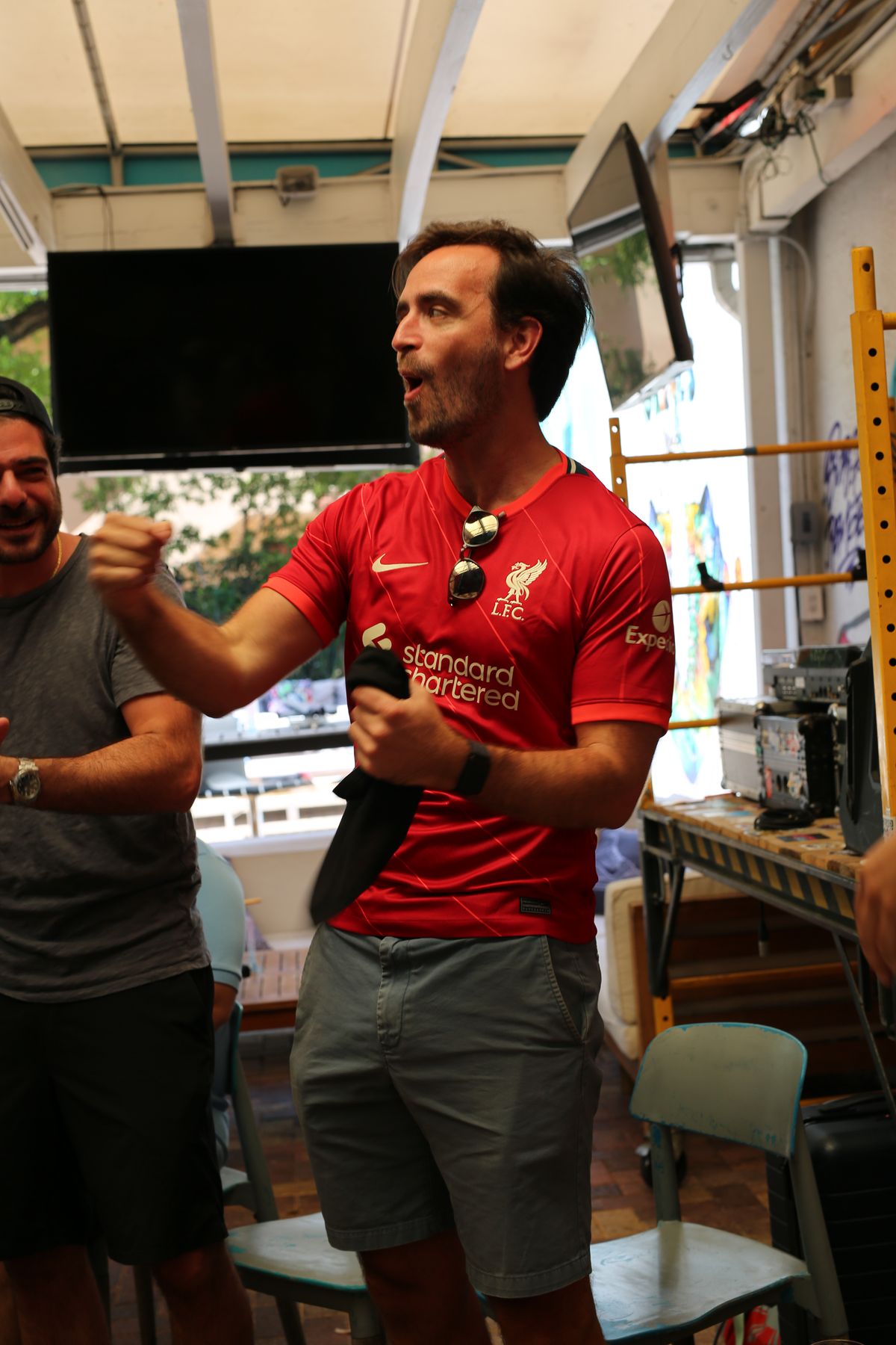 Liverpool FC fan cheering with raised fist during a Premier League watch party at Grails Miami, Miami's home Liverpool bar