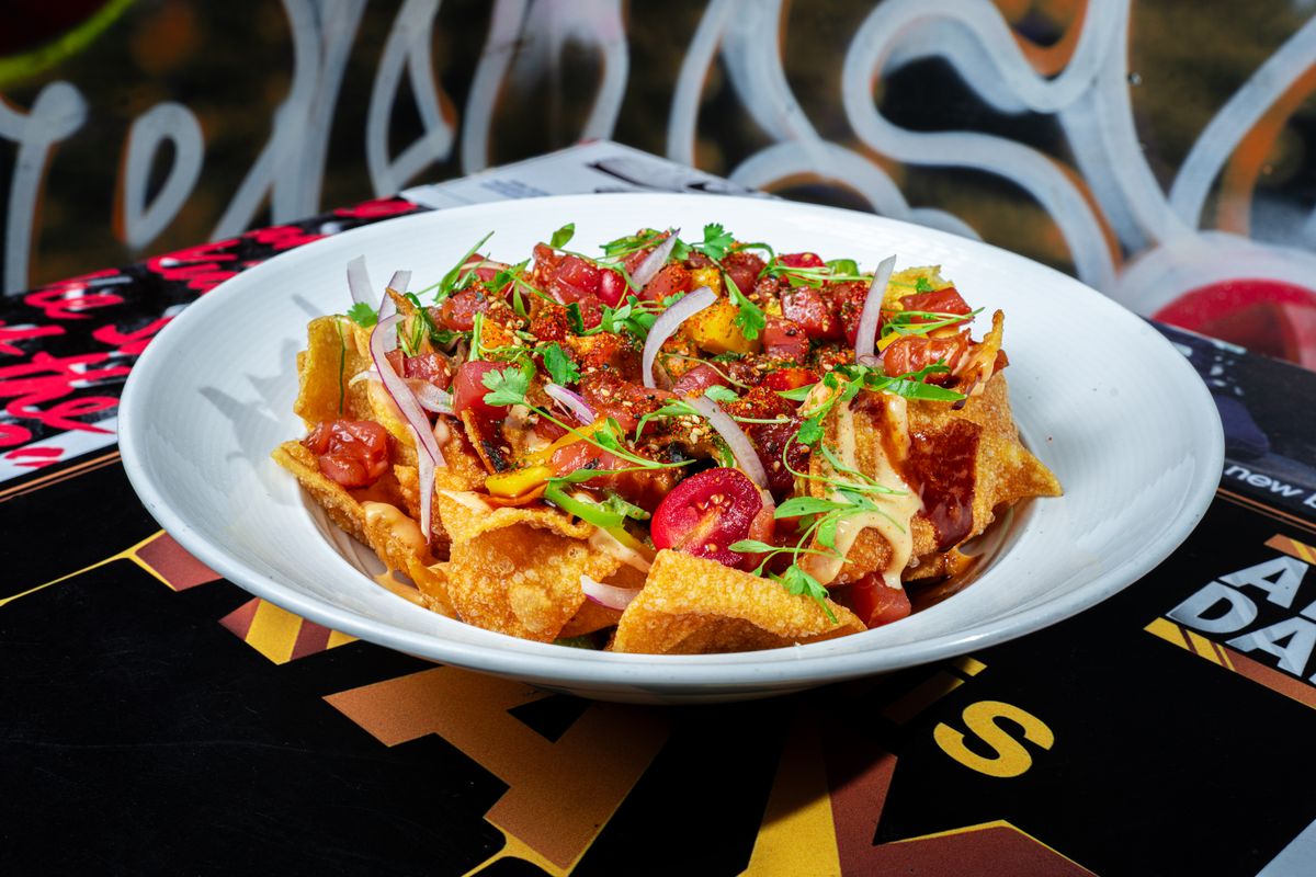 Tuna poke wonton nachos at Grails Miami: ahi tuna, mango, red onion, microgreens and spicy aioli over crispy wontons in a white bowl