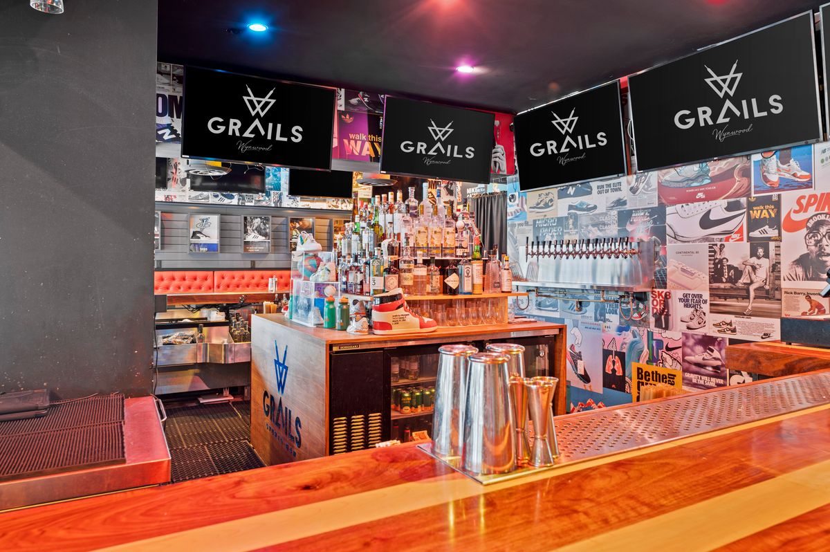 Grails Miami indoor bar counter with the sneaker-wall backdrop — the defining feature of the Sneaker Lounge.