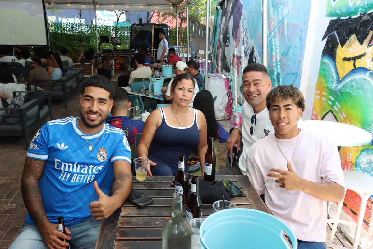 Family of four with one fan in a Real Madrid jersey at a Grails Miami patio table during a La Liga match