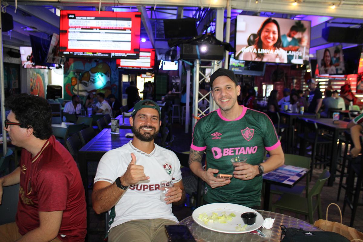 Fluminense fan couple together at a Grails Miami table during a Brasileirão match