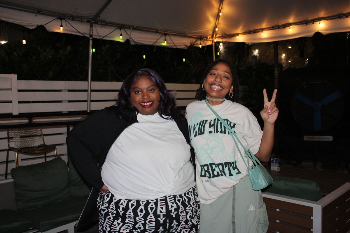 Two women on the Grails Miami patio at night during a WNBA watch party, Miami's WNBA sports bar