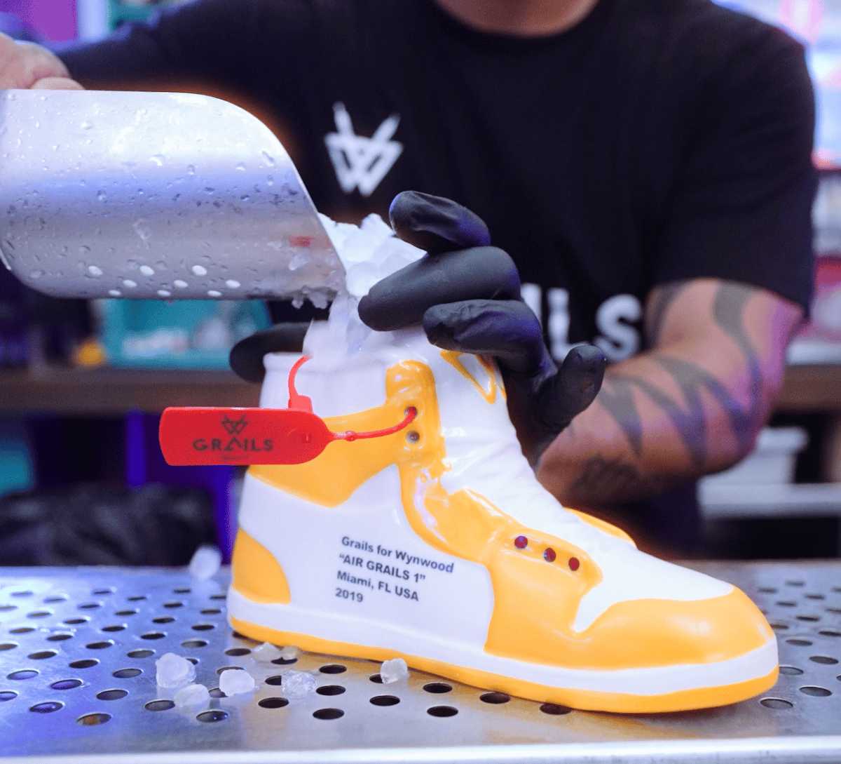 Bartender pouring ice into the Air Grails 1 sneaker cocktail vessel at Grails Miami in Wynwood