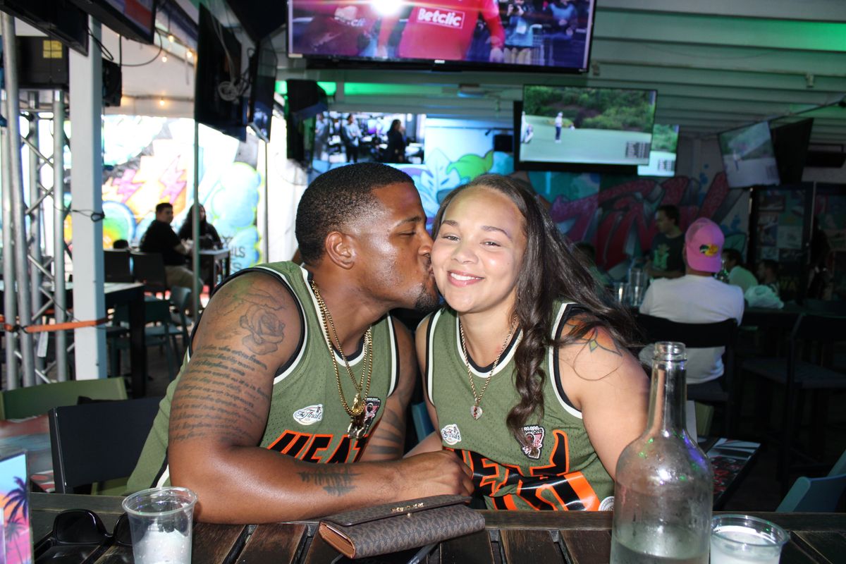 Couple in matching Miami Heat NBA Finals jerseys at the Grails Miami bar during a Heat watch party