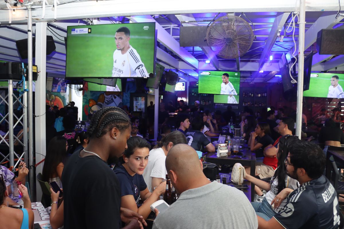 Packed indoor crowd watching a European soccer match on multiple big screens at Grails Miami, Miami's #1 Europa League sports bar