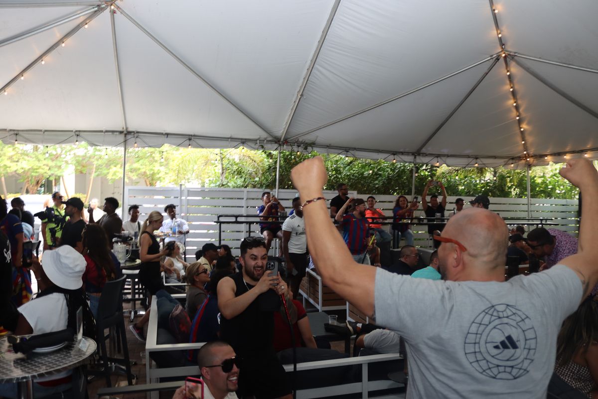 Real Madrid fan raising both fists in celebration during a Champions League watch party at Grails Miami
