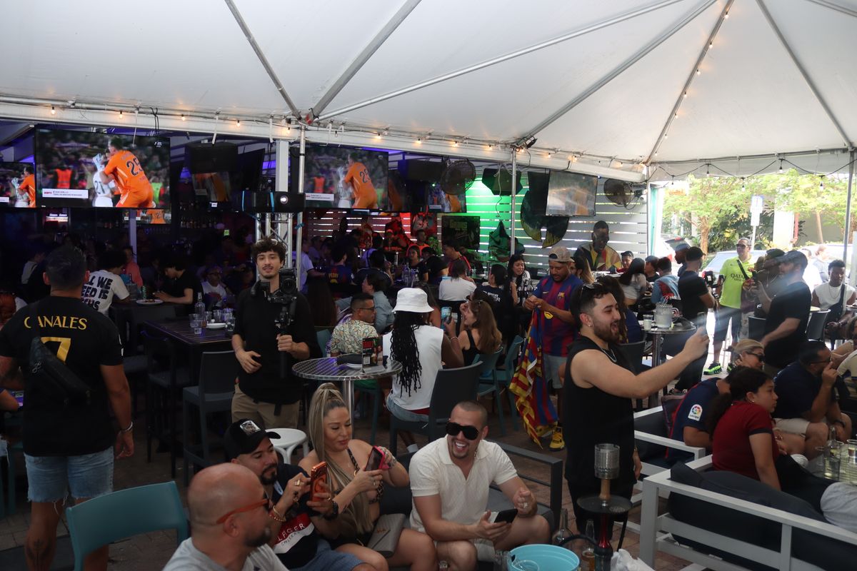 Wide crowd of soccer fans on the Grails Miami patio during a Liga MX matchday