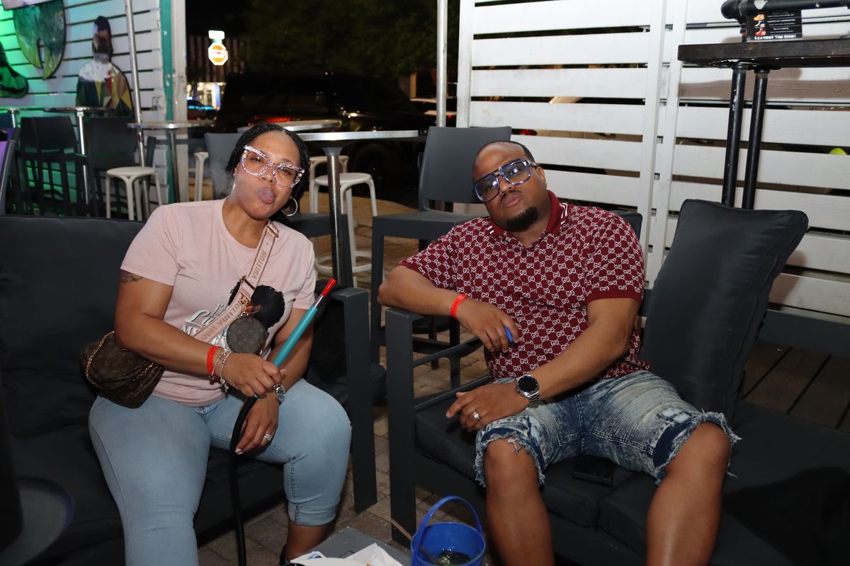 Couple on a lounge couch with hookah at Grails Miami patio at night — date-night hookah in Miami