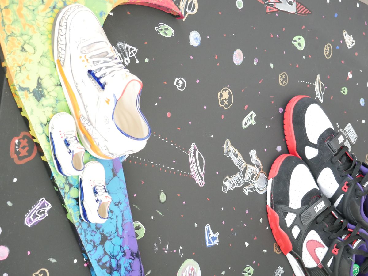 The indoor Sneaker Lounge bar at Grails Miami in Wynwood, with the wall of rare sneakers and sports on the overhead TVs