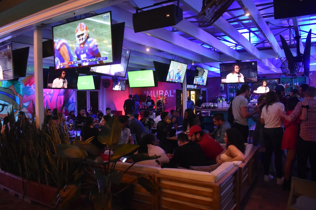 Packed Grails Miami lounge with a Florida Gators game on the big screen during a Florida vs Alabama watch party