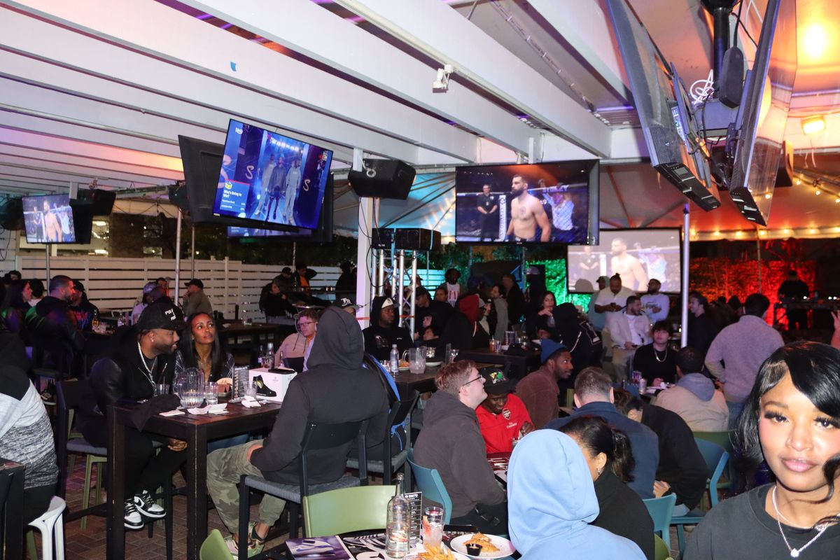 Crowd filling the covered patio on a UFC fight night at Grails Miami in Wynwood, a five minute drive from Edgewater