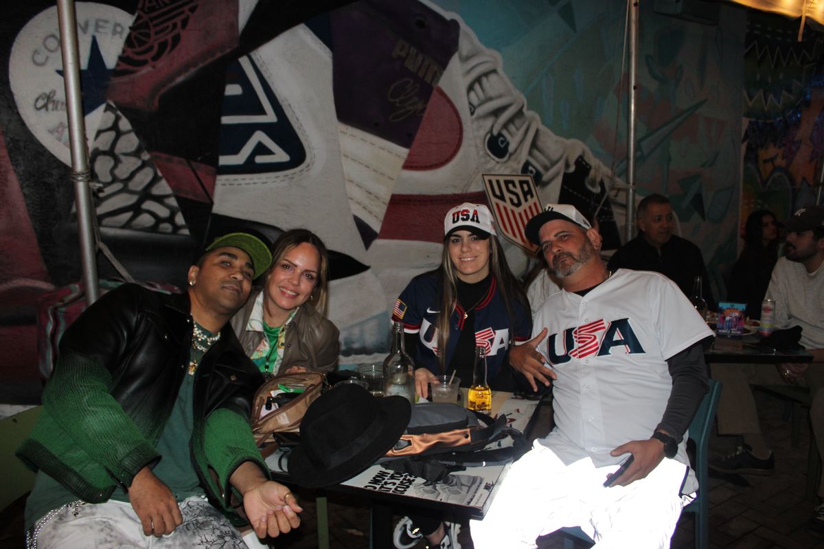 Group of four USMNT soccer fans posing in front of the Grails Wynwood sneaker mural during a Concacaf Gold Cup watch party