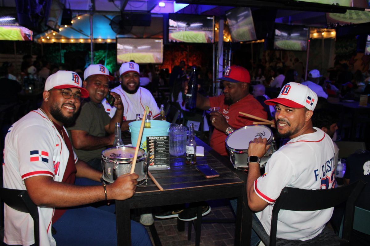 Dominican Republic baseball fans with snare drums and Coronas around a Grails Wynwood table during a Miami Marlins game