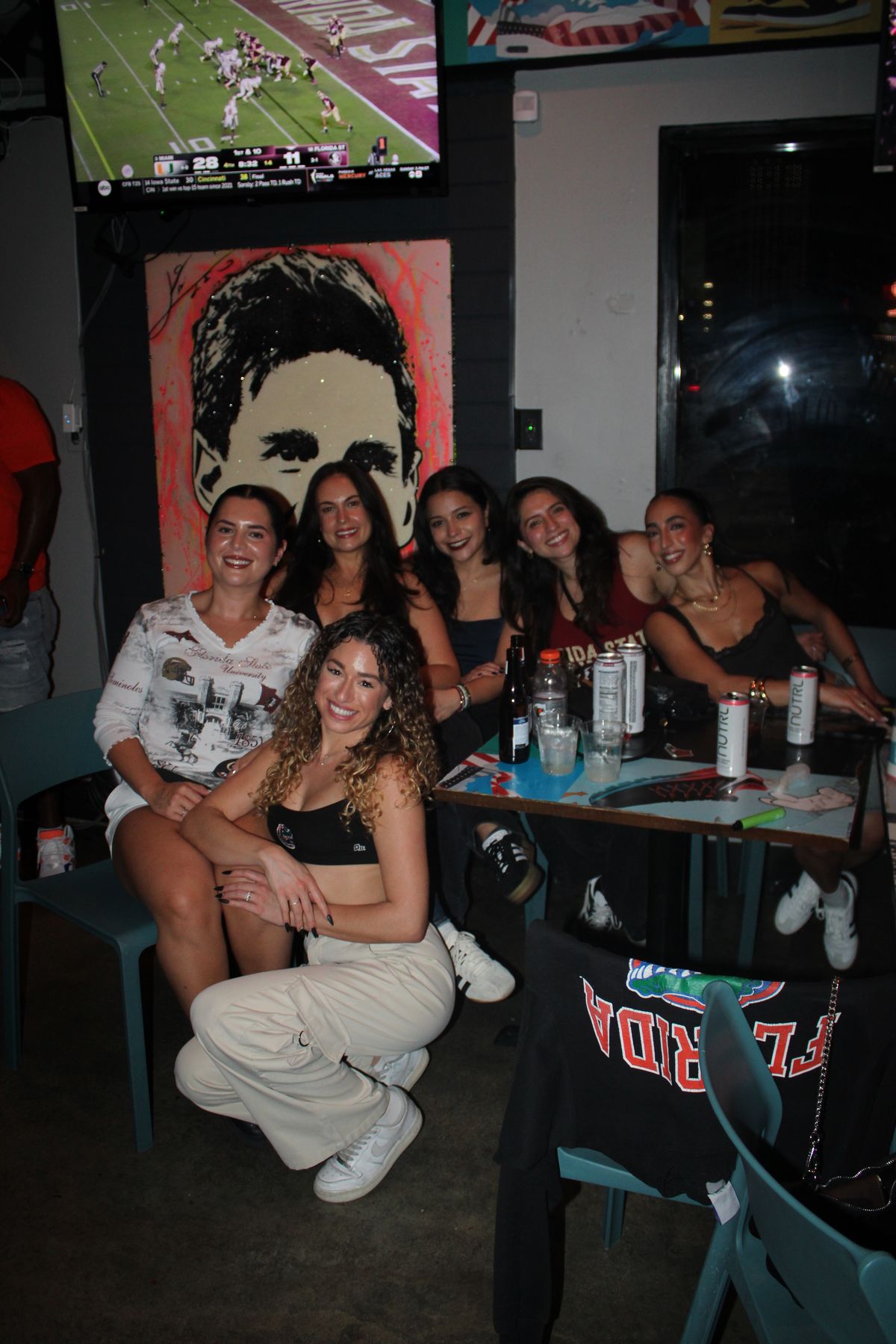 Six Florida State Seminoles fans in garnet FSU shirts around a table at Grails Miami, the Florida State Seminoles sports bar in Wynwood