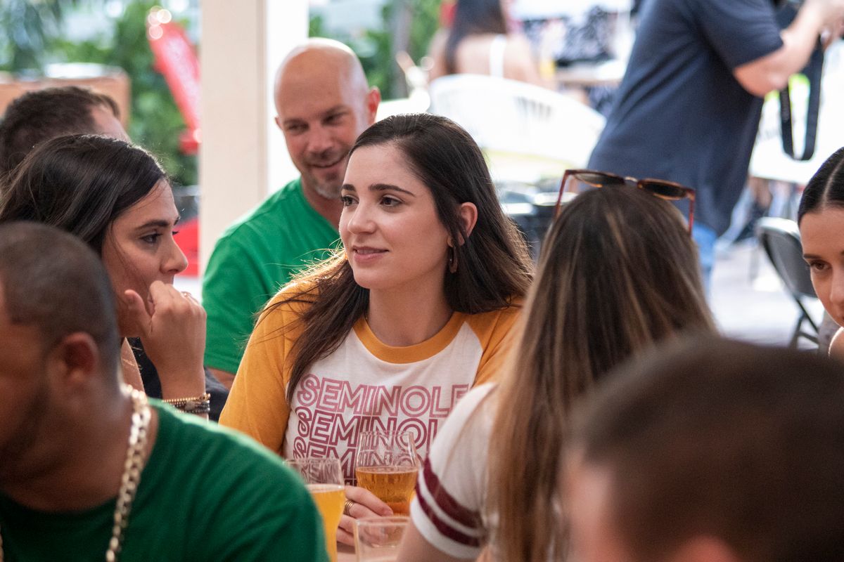 Florida State Seminoles fan in a Seminoles ringer tee with a beer at a Grails Miami watch party table in Wynwood