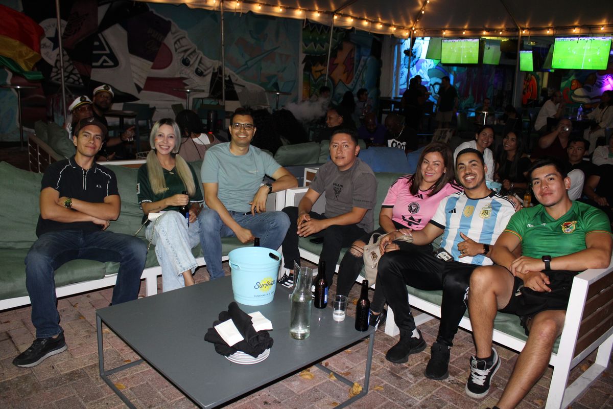 Group of friends in Inter Miami, Argentina and Bolivia jerseys posing on the Grails Wynwood patio for a Concacaf Champions Cup match