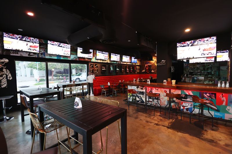 Inside Grails Miami with sneaker-themed bar, red booths, and big-screen TVs