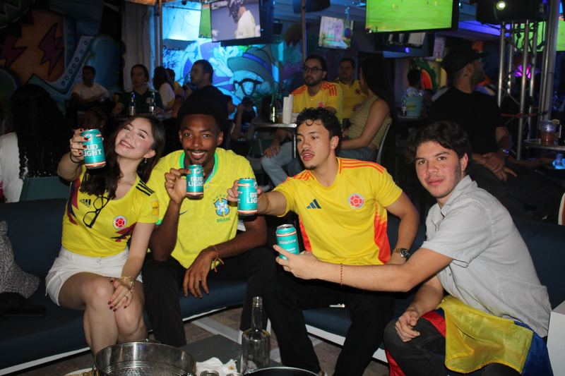 Colombia and Brazil fans sharing a toast at the bar during a South American soccer watch party at Grails Miami