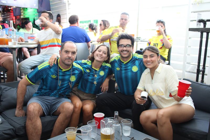 Four friends in Colombia away jerseys on the patio couches at Grails Miami before a Colombia national team match