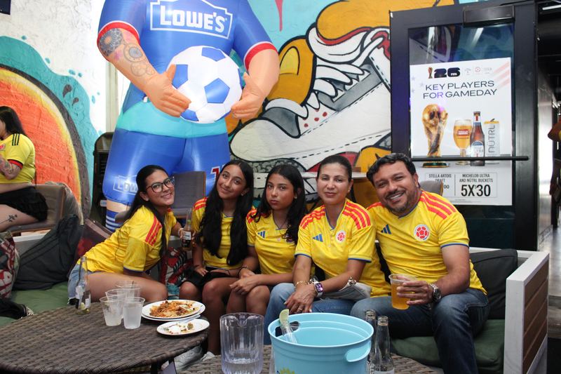 Family of five Colombia fans in yellow jerseys on a couch at Grails Miami, the family-friendly Colombian soccer bar in Wynwood